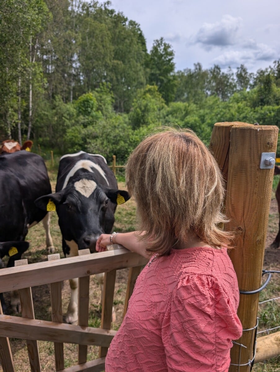 Vår gruppledare Åsa Dahl tillsammans med kor i hage som bidrar till naturvård i Salem